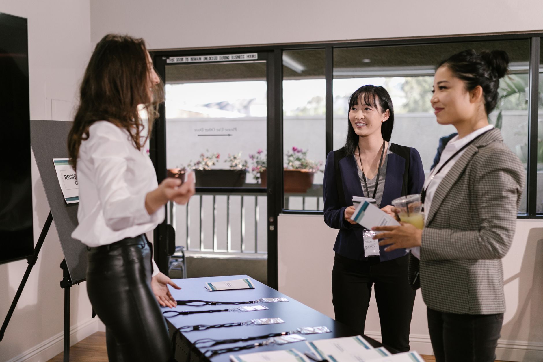 Delegates collecting name badges and lanyards at a conference registration desk