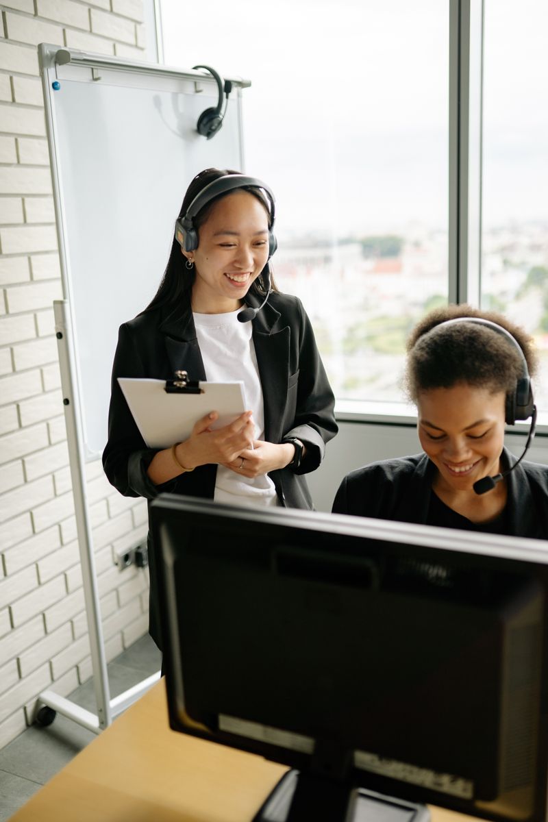 Two travel support agents wearing headsets at their desks